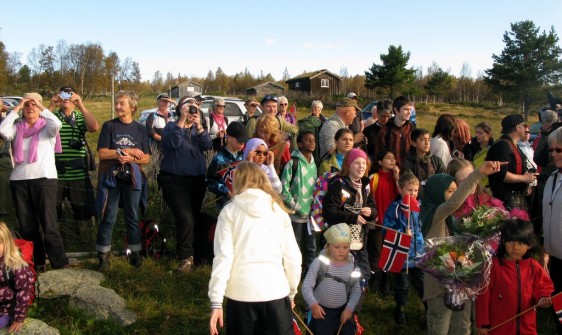 Bilde avtilskuere som for et øyeblikk retter blikket mot reinsfjellet. Foto Hans Sollid