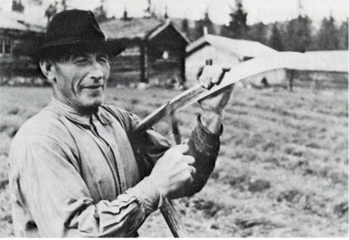 Bilde av Embret Finstad som bryner ljåen. Foto utlånt av fam. Nielsen